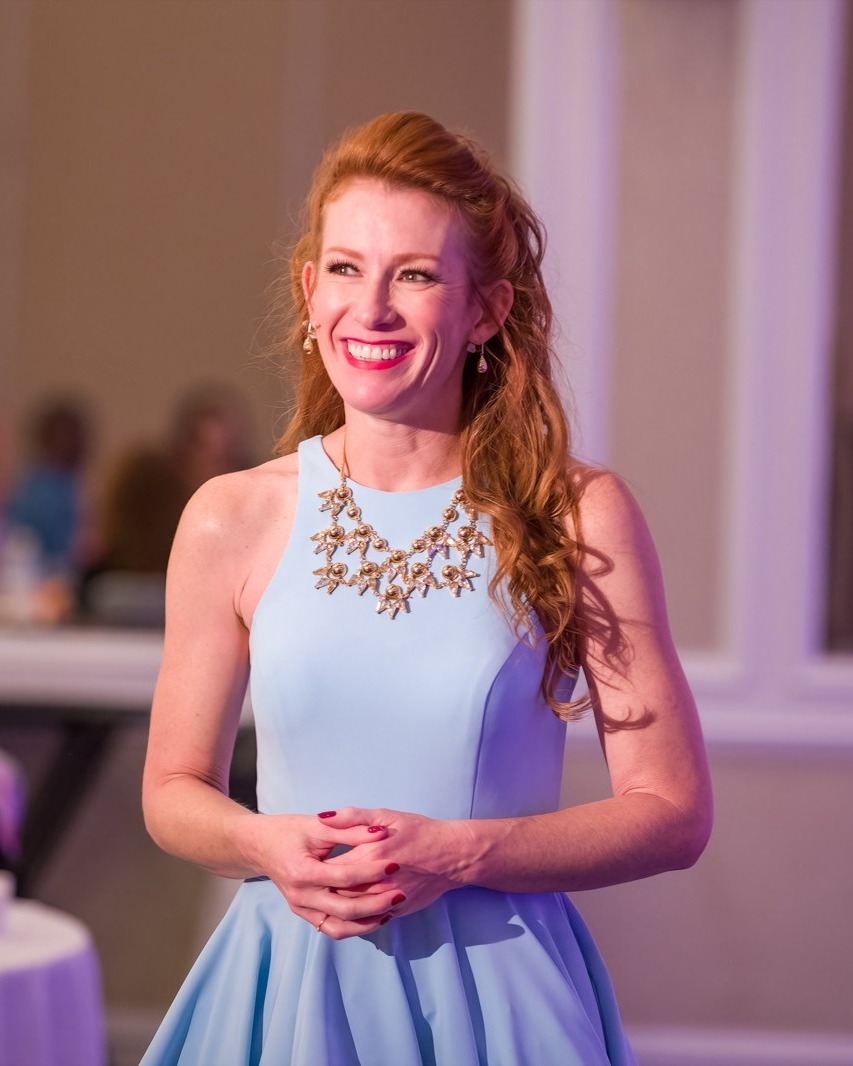 Tamara Rose, host of the Rose Report, smiling in a light blue dress