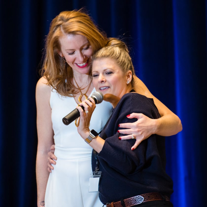 Tamara Rose hugging a client on stage