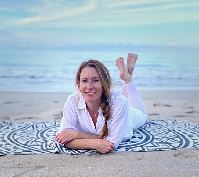 Tamara Rose relaxing on a blanket on the beach, smiling