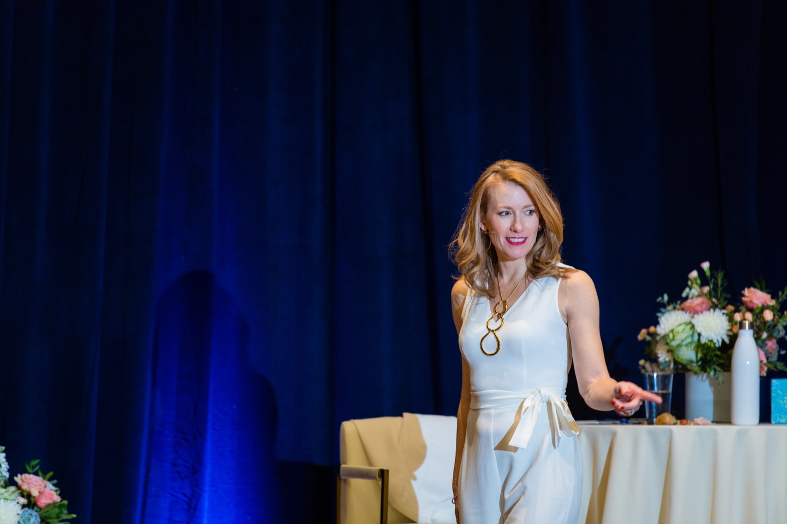 Tamara Rose teaching on stage in a white jumpsuit